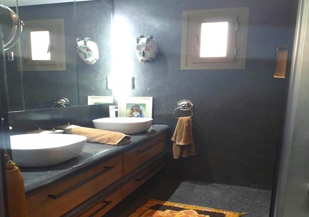 A bathroom with two sinks, a mirror, and a towel rack.