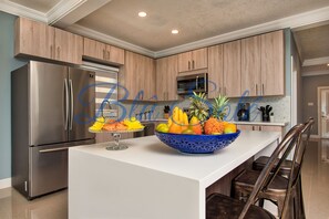 Enjoy cooking in this well-equipped kitchen with a central island, stainless steel appliances, and ample cabinetry.