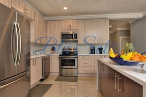 Enjoy cooking in this well-equipped kitchen with a refrigerator, oven, and ample countertop space.