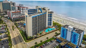 A high-rise hotel with multiple balconies, a swimming pool, and a beach view. - WOW CORNER ALL GLASS PARLOR UNIT/60 FOOT OF BALCONY/2 BALCONIES (Myrtle Beach)