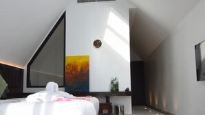 Une chambre à coucher moderne avec une lucarne, un grand lit et un décor minimaliste.
