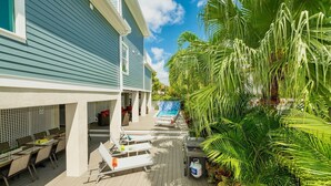 Un espace aménagé au bord de la piscine, avec des chaises longues, un barbecue et un coin repas.