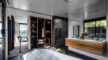 A modern bathroom with a large bathtub, a walk-in shower, and a vanity with a mirror.