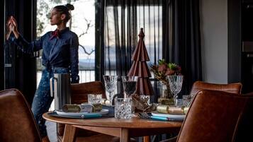 Una mesa de comedor dispuesta con copas de vino, una botella y un paraguas decorativo.