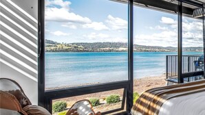 A room with a large window overlooking a lake, a bed, and a chair. - Deviot Boat House - romantic, absolute waterfront (Deviot)
