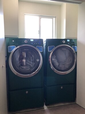 Convenient laundry facilities feature two front-loading washing machines.