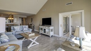 Un salon spacieux comprenant un canapé, une table basse, un meuble pour la télévision et un coin repas.