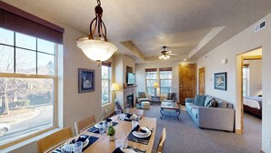 A dining area with a table set for four, a sofa, and a fireplace. - Foxpoint 2 Bedroom Condo by RedAwning (Park City)