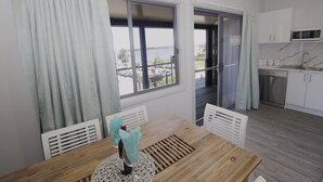 A modern kitchen with white cabinets, a microwave, and a stainless steel dishwasher. - UNIT   1.. OPPOSITE THE OCEAN.. BEACH ..RIVER..PET FRIENDLY. 1 FREE PARKING  
 
 (HARRINGTON)