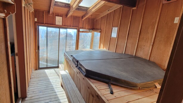 A wooden cabin with a sliding glass door leading to a deck. - Funky and Charming Home! (Laramie)