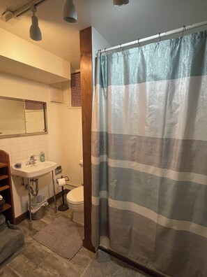 Tina con regadera, toallas, jabón, shampoo 