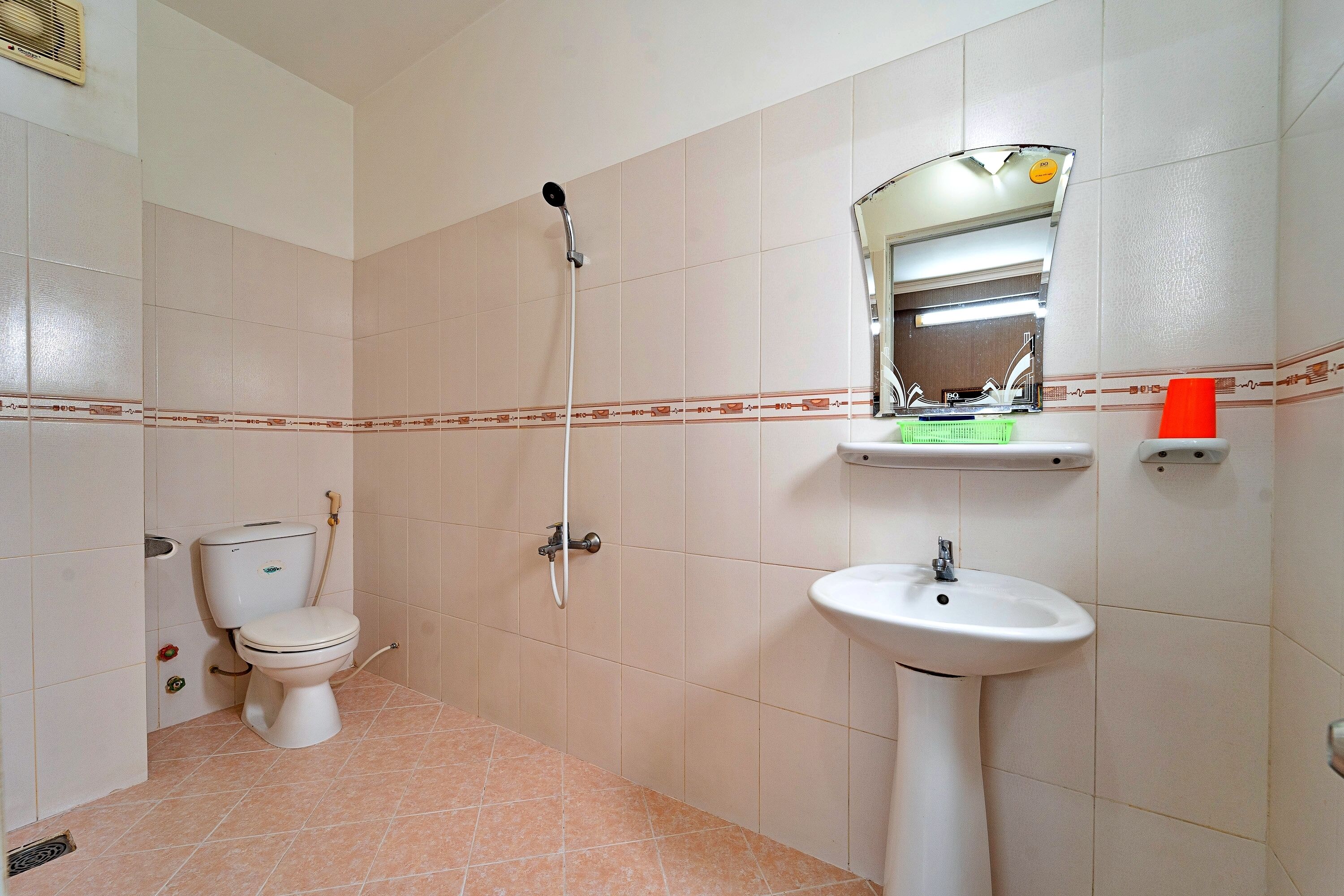 Een badkamer met toilet, wastafel en douche.
