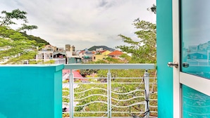 A balcony with a turquoise railing overlooking a cityscape with various buildings and a hill in the background. - S79 Bao Khoi Hotel (Ho Chi Minh City)