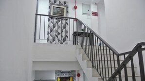 Eine Treppe mit Wand in geometrischem Muster und einem Gemälde darüber.