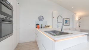 Una cucina moderna con elettrodomestici integrati, un'isola centrale e un design minimalista.