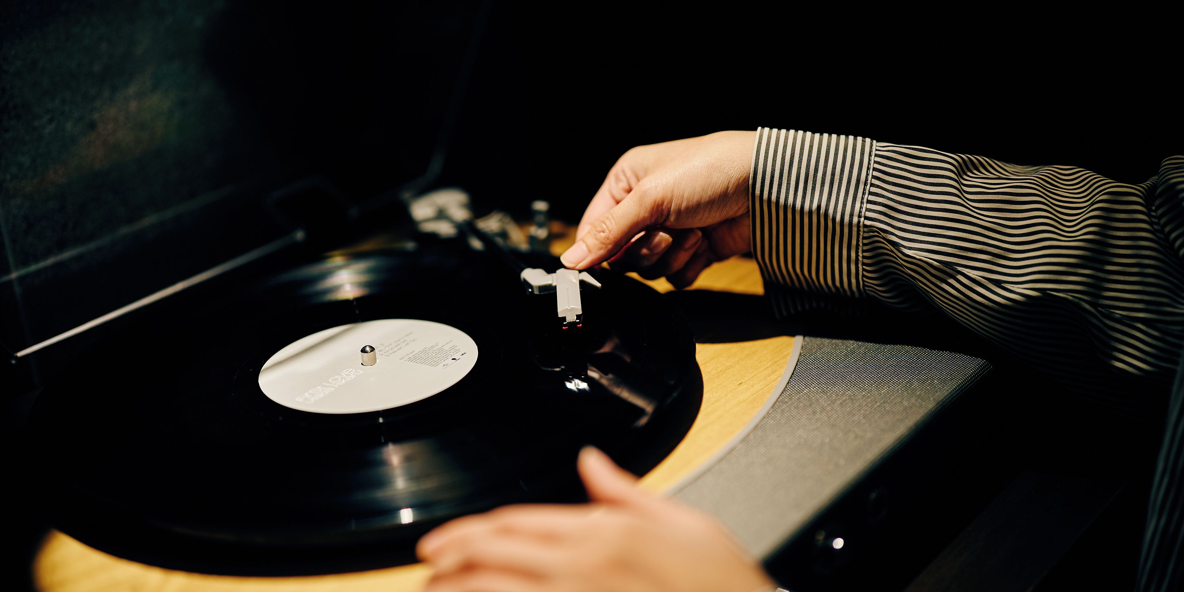 Une personne qui règle une platine vinyle.