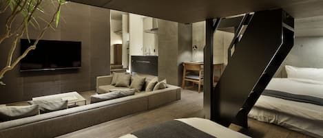 Un intérieur moderne avec un canapé, un lit, un téléviseur et un escalier.
