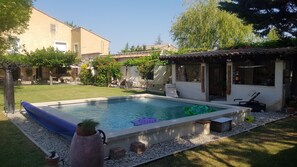 Relax by the pool surrounded by lush greenery and outdoor furniture.