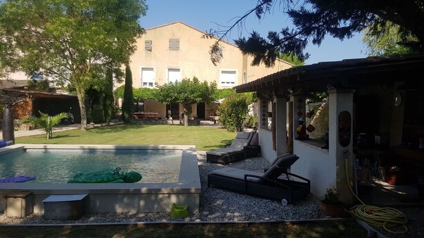Un pati interior amb piscina, gandules i una zona de terrassa coberta.