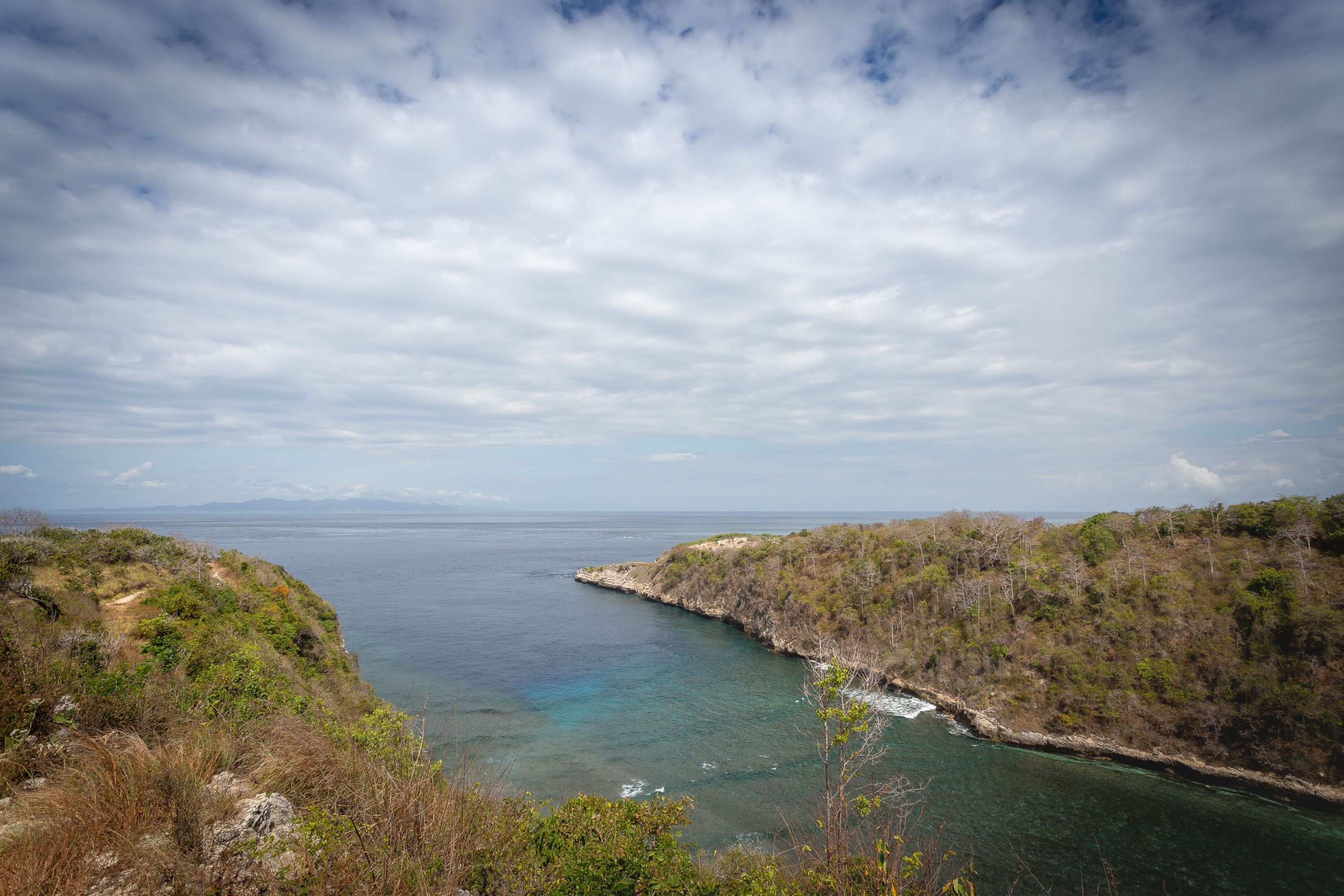 Un paysage côtier offrant une vue dégagée sur la mer et une côte rocheuse.