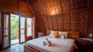 A bedroom with a wooden ceiling, a bed with white linens, a wooden headboard, and a nightstand with a lamp. - Penida Krusty Hill (Penida Island)