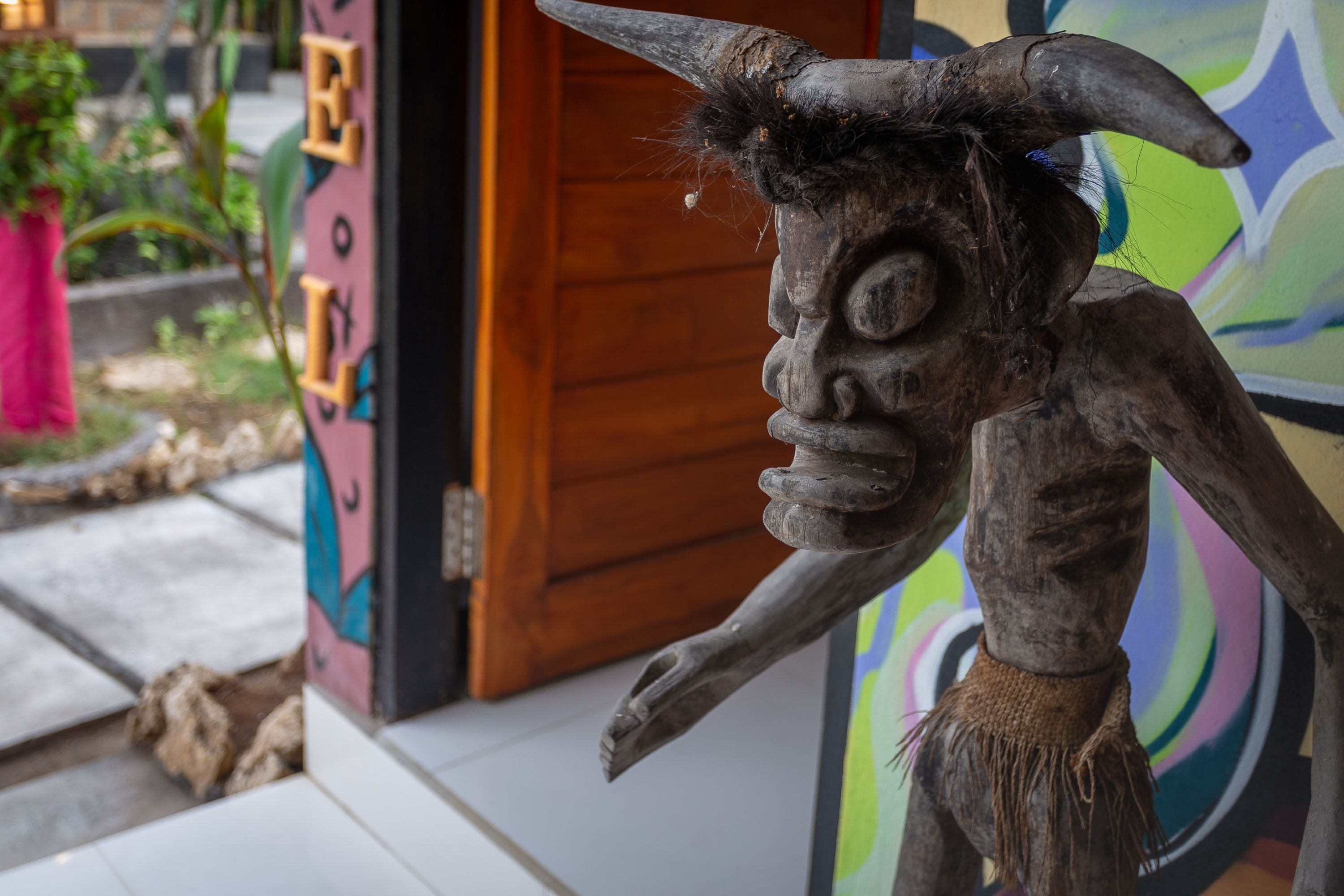 A sculpture of a bull with a wooden texture and a rope around its neck.
