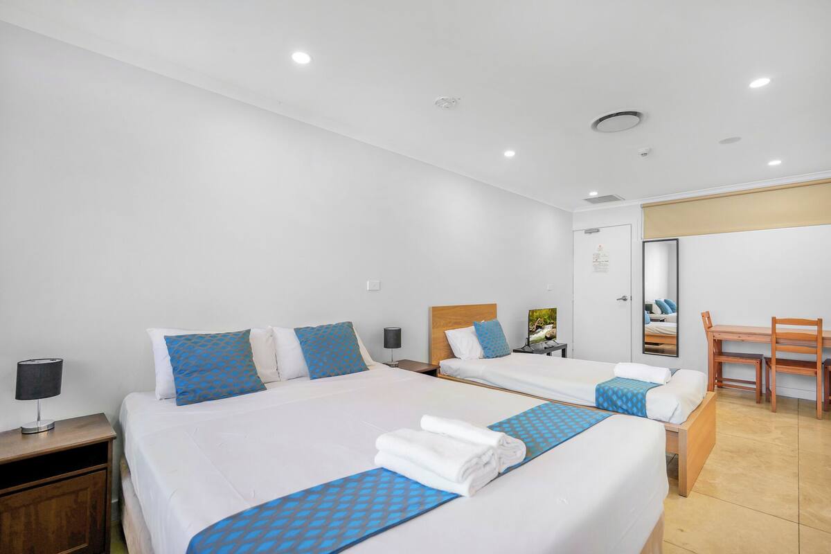 Ein Hotelzimmer mit zwei Betten, einem Schreibtisch und einem Sessel.