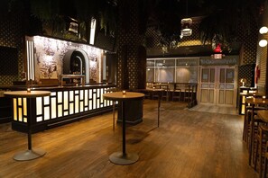 A bar area with a counter, tables, and chairs, and a separate dining area with a sign reading 'EXIT'. - Springhill Suites Midtown Manhattan/park Avenue (New York)