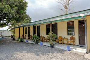 A building with a covered porch, outdoor seating, and potted plants. - Spot On 1847 Hotel Maya (Beru)