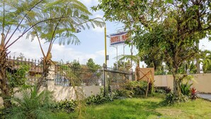A fenced garden area with a sign for a hotel. - Spot On 1847 Hotel Maya (Beru)