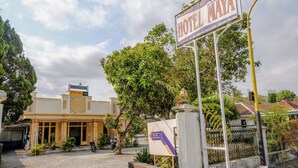 A hotel entrance with a sign for Hotel Maya, a dirt driveway, and a motorcycle parked outside. - Spot On 1847 Hotel Maya (Beru)