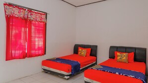 A room with two beds, each with red bedding and patterned pillows, a window with red curtains, and a tiled floor. - Spot On 1847 Hotel Maya (Beru)