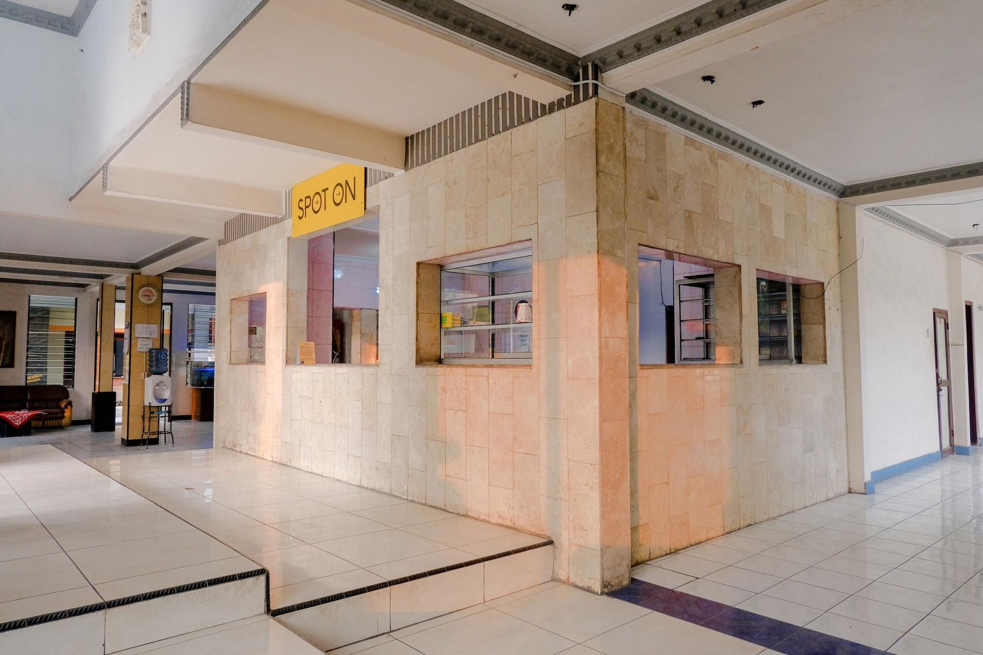 A spot-on kiosk in a spacious indoor area with tiled floors and a high ceiling.