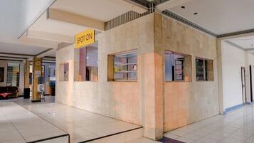 A spot-on kiosk in a spacious indoor area with tiled floors and a high ceiling.