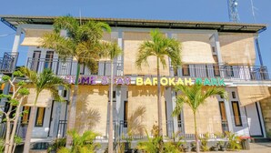 A multi-story building with balconies, palm trees, and a sign reading 'HOMESTAY BAROKAH PARK'. - Spot On 1958 Asembagus Family (Asembagus)
