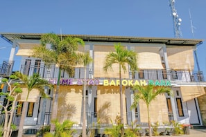 A multi-story building with balconies, palm trees, and a sign reading 'HOMESTAY BAROKAH PARK'. - Spot On 1958 Asembagus Family (Asembagus)
