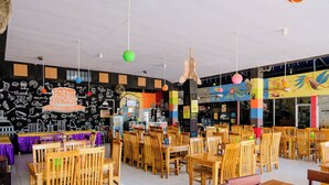 A restaurant with wooden tables and chairs, a blackboard wall with doodles, and hanging spherical lights. - Spot On 1958 Asembagus Family (Asembagus)