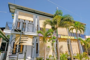 Un hotel con balcón, palmeras y un cartel que dice 'HOTEL BAROKAH'.