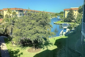 A hotel with a river view, a boat dock, and a well-maintained garden. - Across from Beach, Stunning Canal Views, Age 55 up (Siesta Key)