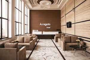 Un moderno vestíbulo de hotel con mostrador de recepción, sofás y suelo de mármol.