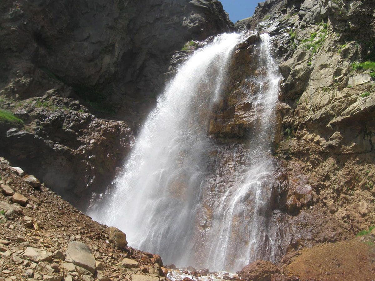 Uma cascata despencando por um penhasco rochoso.