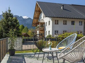 Een balkon met stoelen, een tafel en een potplant.