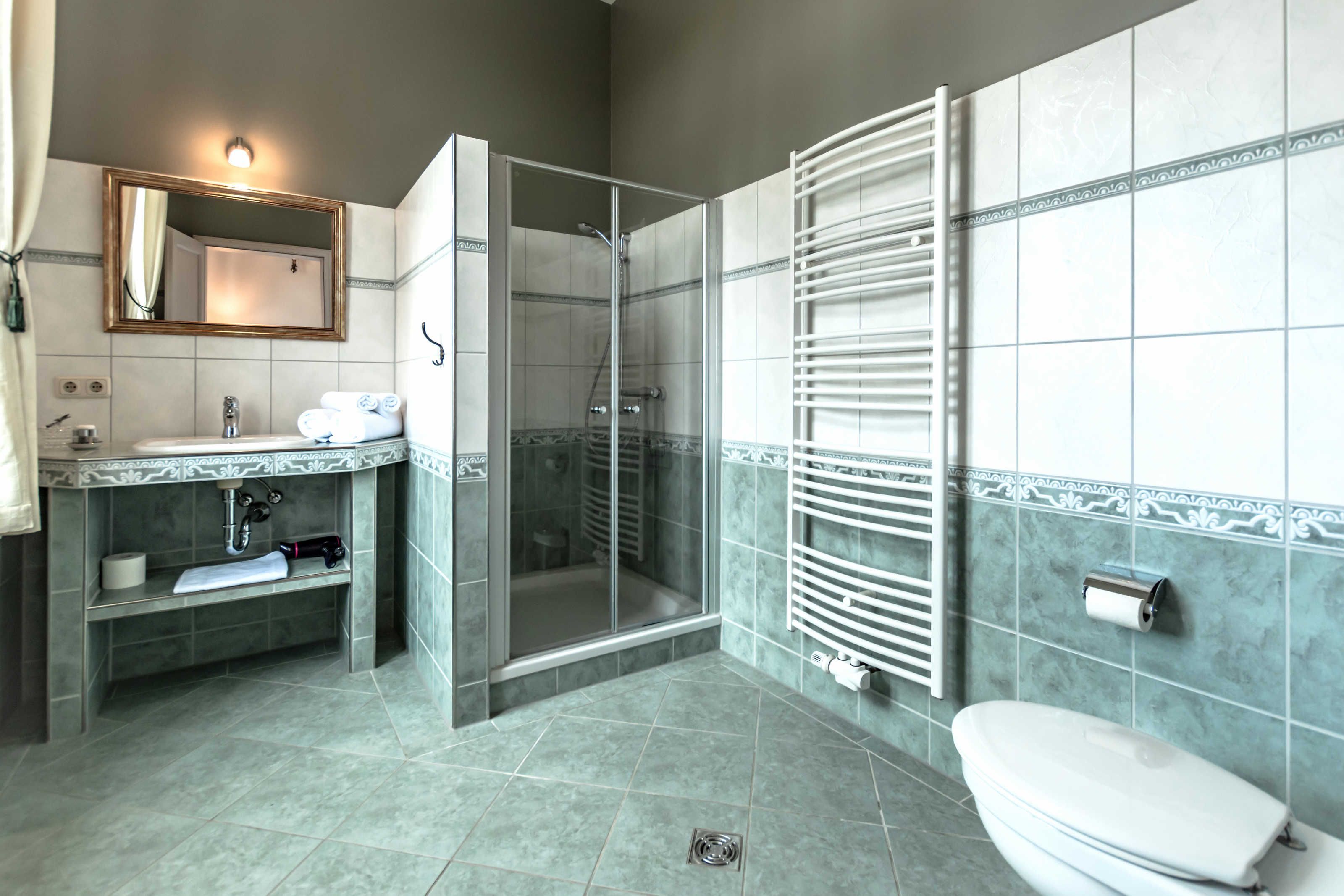 A modern bathroom with a shower, toilet, and sink.