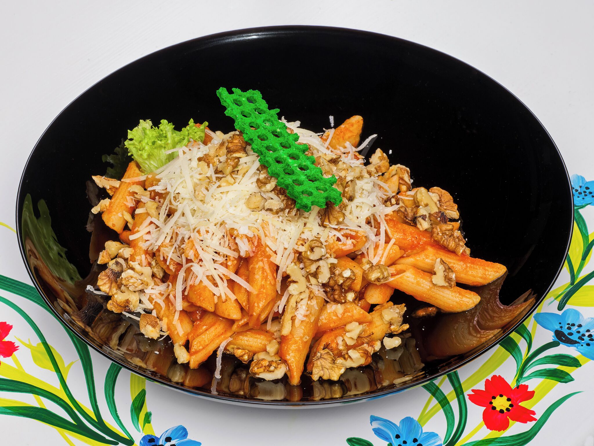 A bowl of pasta with walnuts and grated cheese.