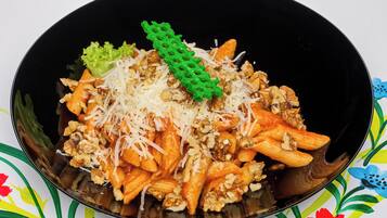 A bowl of pasta with walnuts and grated cheese.