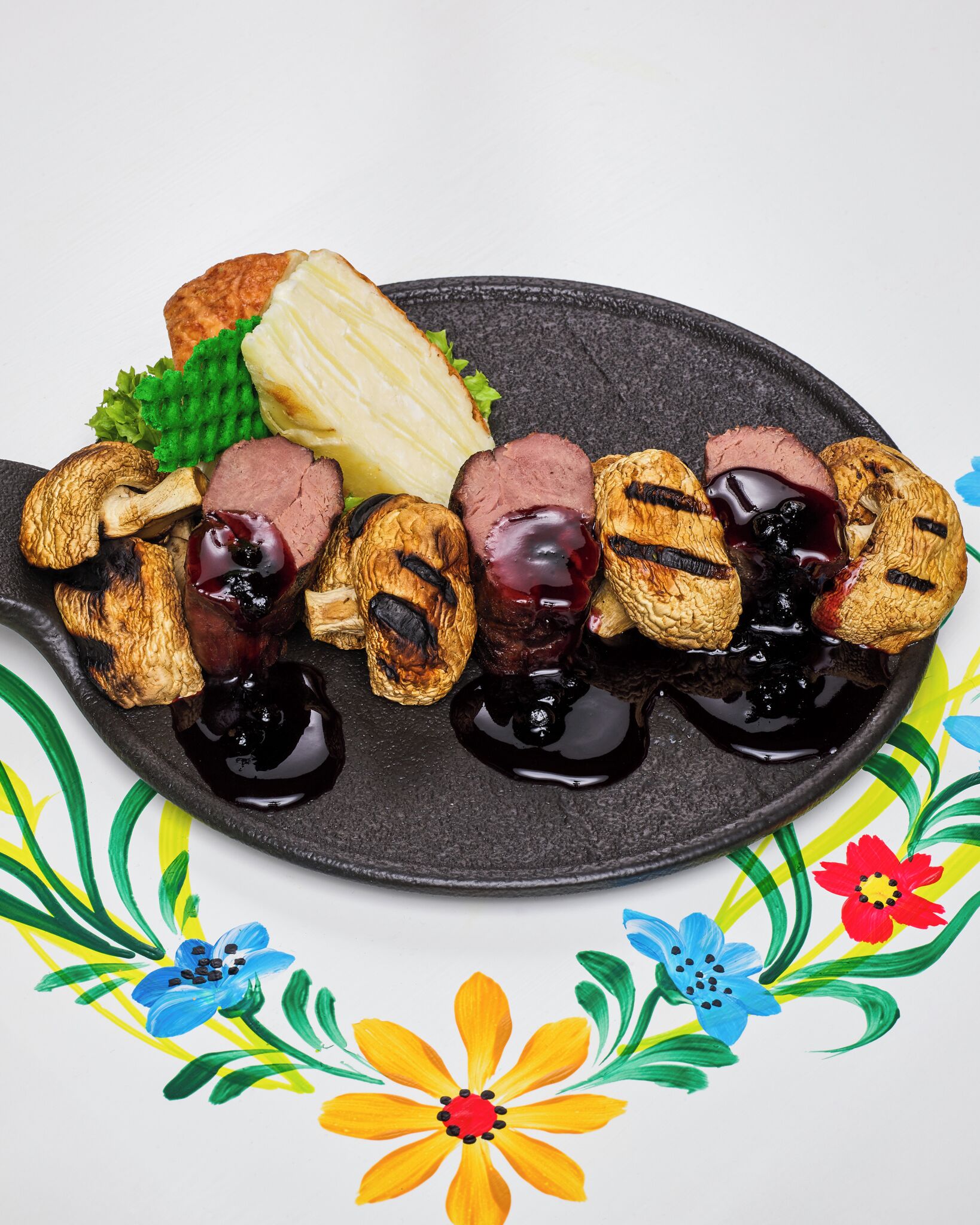 Un plato de comida con champiñones a la parrilla, rebanadas de carne y una rebanada de pan.