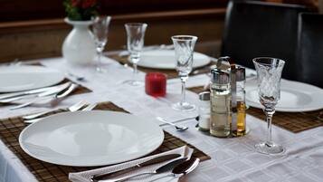 A table set for dining with plates, cutlery, glasses, and a candle.