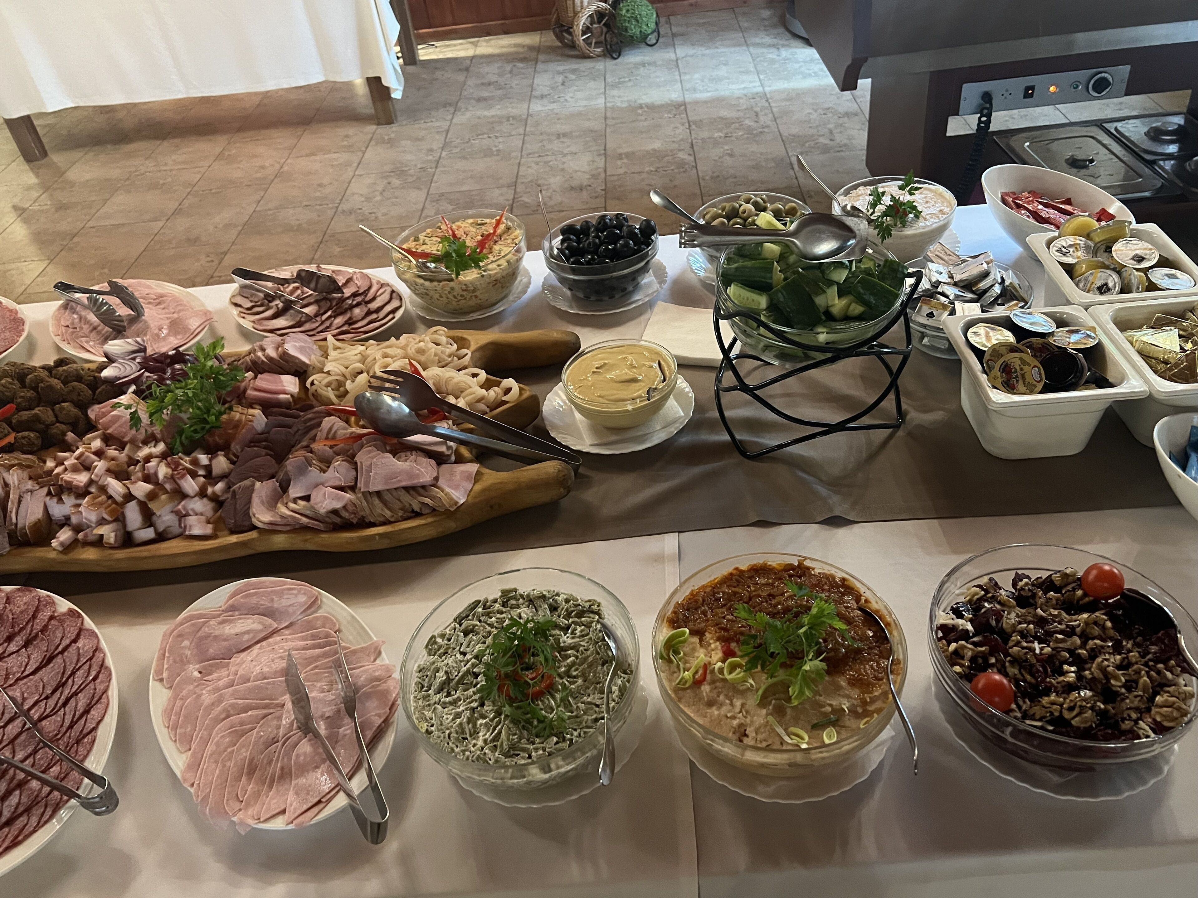 A buffet table with various food items and utensils.