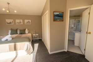 A bedroom with a bed, bedside table, and a painting on the wall. - THE PERFECT GETAWAY - Sunny & Spacious WIFI FREE (Twizel)