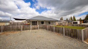 Zona residencial con casas, un patio cercado y un camino de entrada de grava.